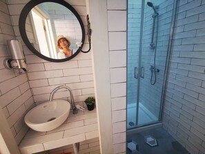 City appartement | Badkamer | Een douche, een regendouche, een haardroger, handdoeken