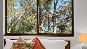 A bedroom with a large window overlooking a forested area. - Over The Boardwalk - North Narooma (North Narooma)
