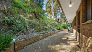 A narrow pathway leading to a building with a brick exterior and a covered area. - Over The Boardwalk - North Narooma (North Narooma)