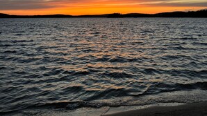 Une plage avec des vagues au coucher du soleil.