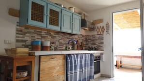 A kitchen with light blue cabinets, a tiled backsplash, and a wooden countertop. - Blue House (Castro)
