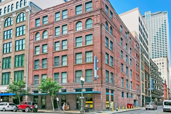 A multi-story brick building with large windows and a flat facade. - Merchant Lofts Comfy Condos – Walk Everywhere (New Orleans)