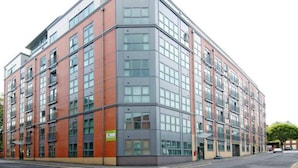 A multi-story building with a modern architectural design, featuring a mix of brick and glass facades. - 1 Bedroom Flat - Lace Market Nottingham (Nottingham)