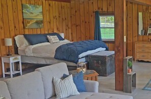 Relax in this inviting room with a large bed, sofa, and dresser, perfect for unwinding.