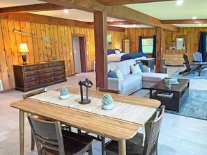 Relax in this inviting space with a large dining table, comfortable seating area, and a dresser for your belongings.