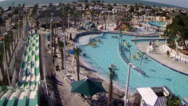 A large outdoor swimming pool with multiple lanes, surrounded by lounge chairs and umbrellas. - Ocean lakes LAKEFRONT MH89A ALL DECKED OUT Newly redecorated (Myrtle Beach)