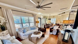 A spacious living room with a large sofa, a coffee table, and a dining area with chairs and a table. - Ocean lakes LAKEFRONT MH89A ALL DECKED OUT Newly redecorated (Myrtle Beach)
