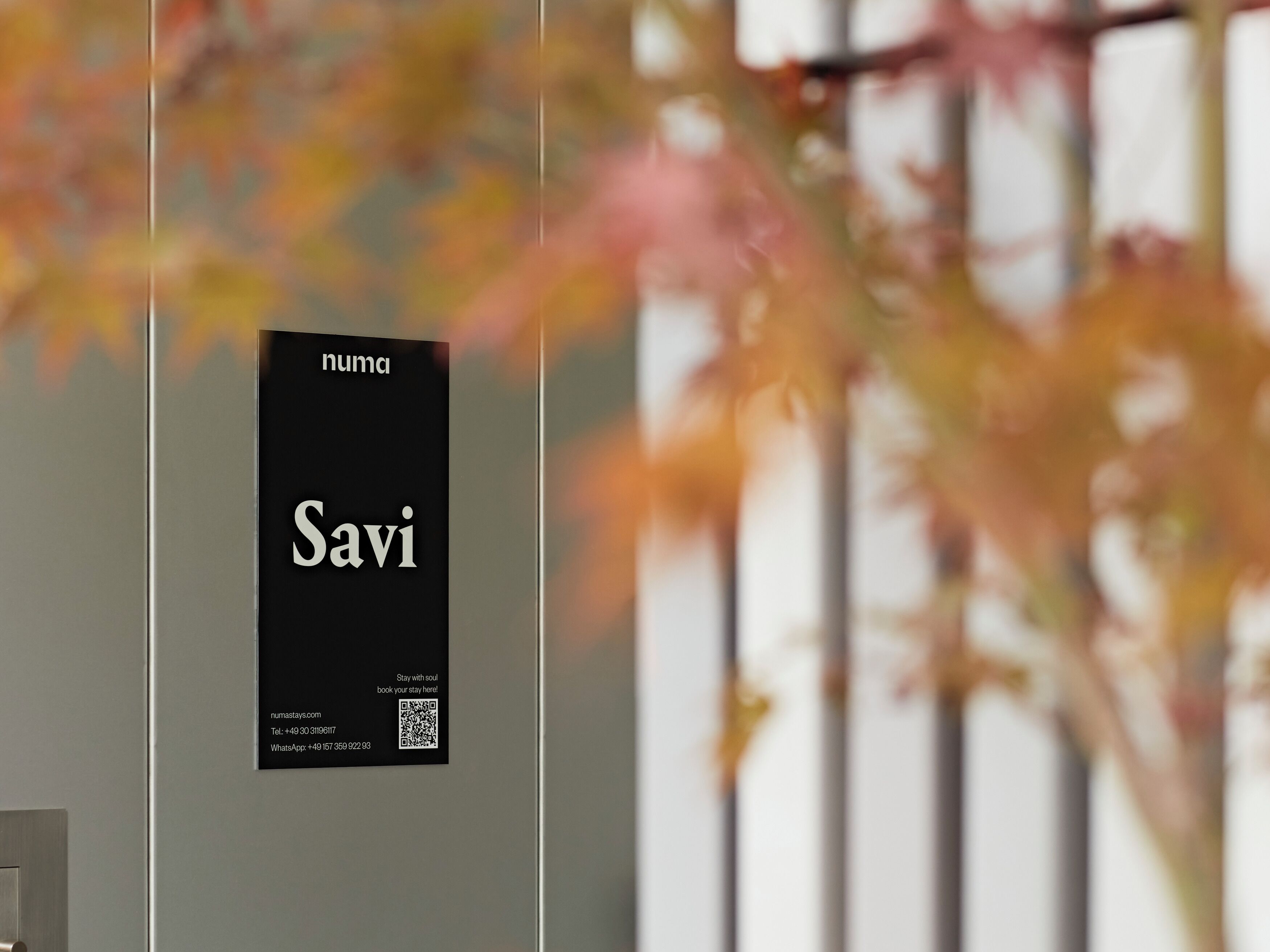 Un letrero negro con texto blanco que dice "Savi" e información de contacto de un hotel.