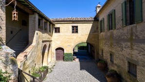 A narrow alleyway with a cobblestone path, stone walls, and arched doorways. - BORGO ANTICO - Nine Bedroom Villa, Sleeps 20 (Montalcino)