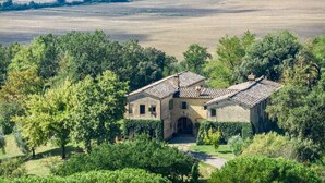 A stone building with a tiled roof, surrounded by lush greenery and trees. - BORGO ANTICO - Nine Bedroom Villa, Sleeps 20 (Montalcino)