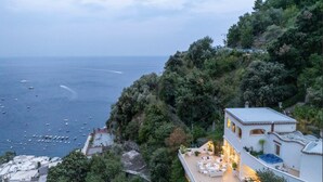 A coastal property with a terrace overlooking the sea, a swimming pool, and a view of boats on the water. - VILLA BIANCA POSITANO (Positano)