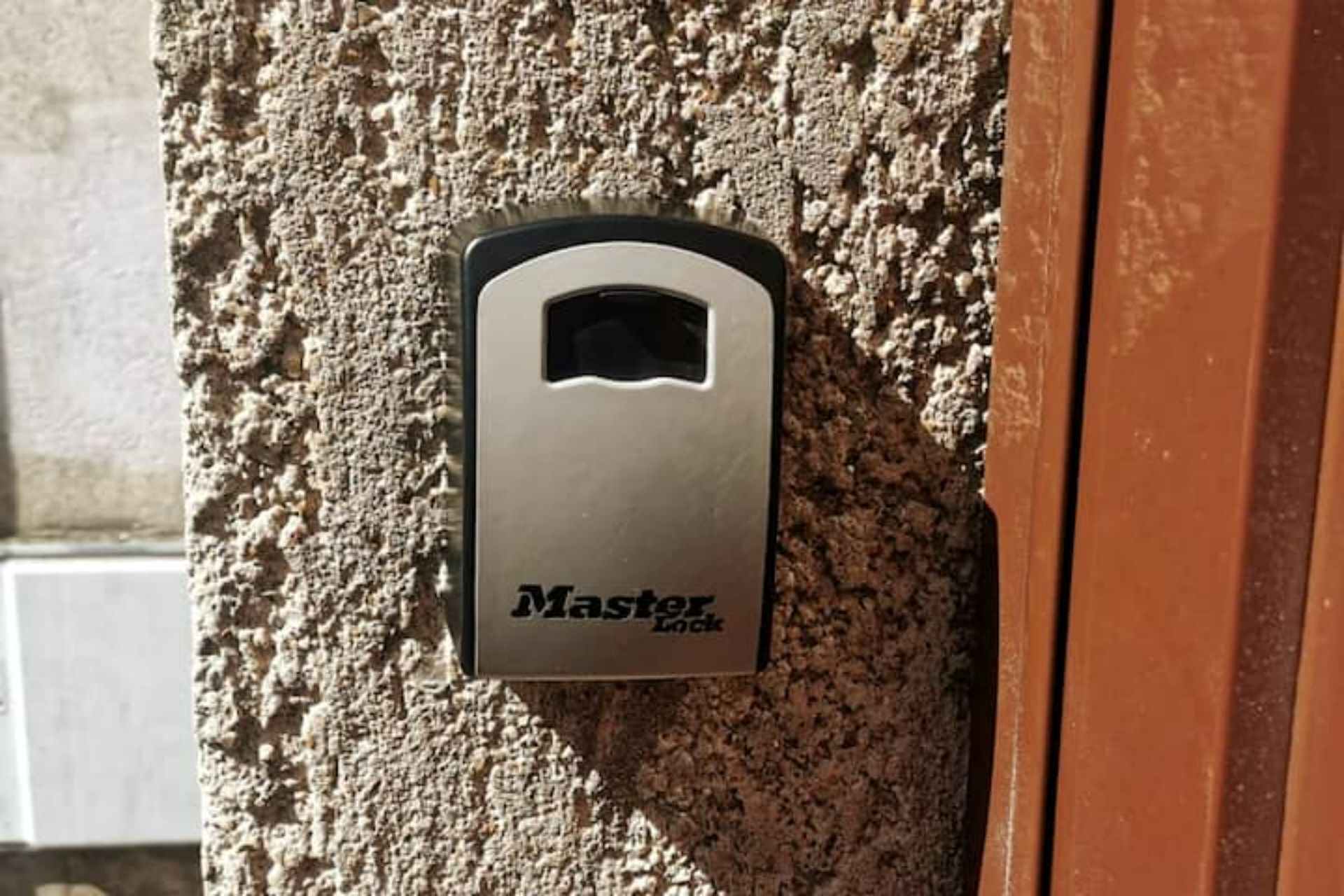Un candado Master Lock en una pared con textura.