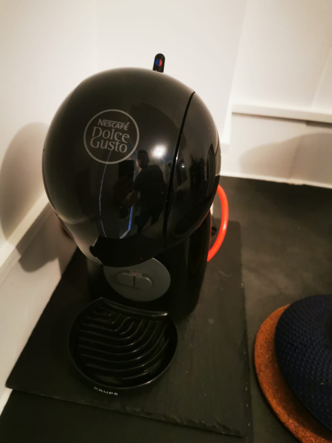 Une machine à café Nescafé Dolce Gusto posée sur un tapis noir.