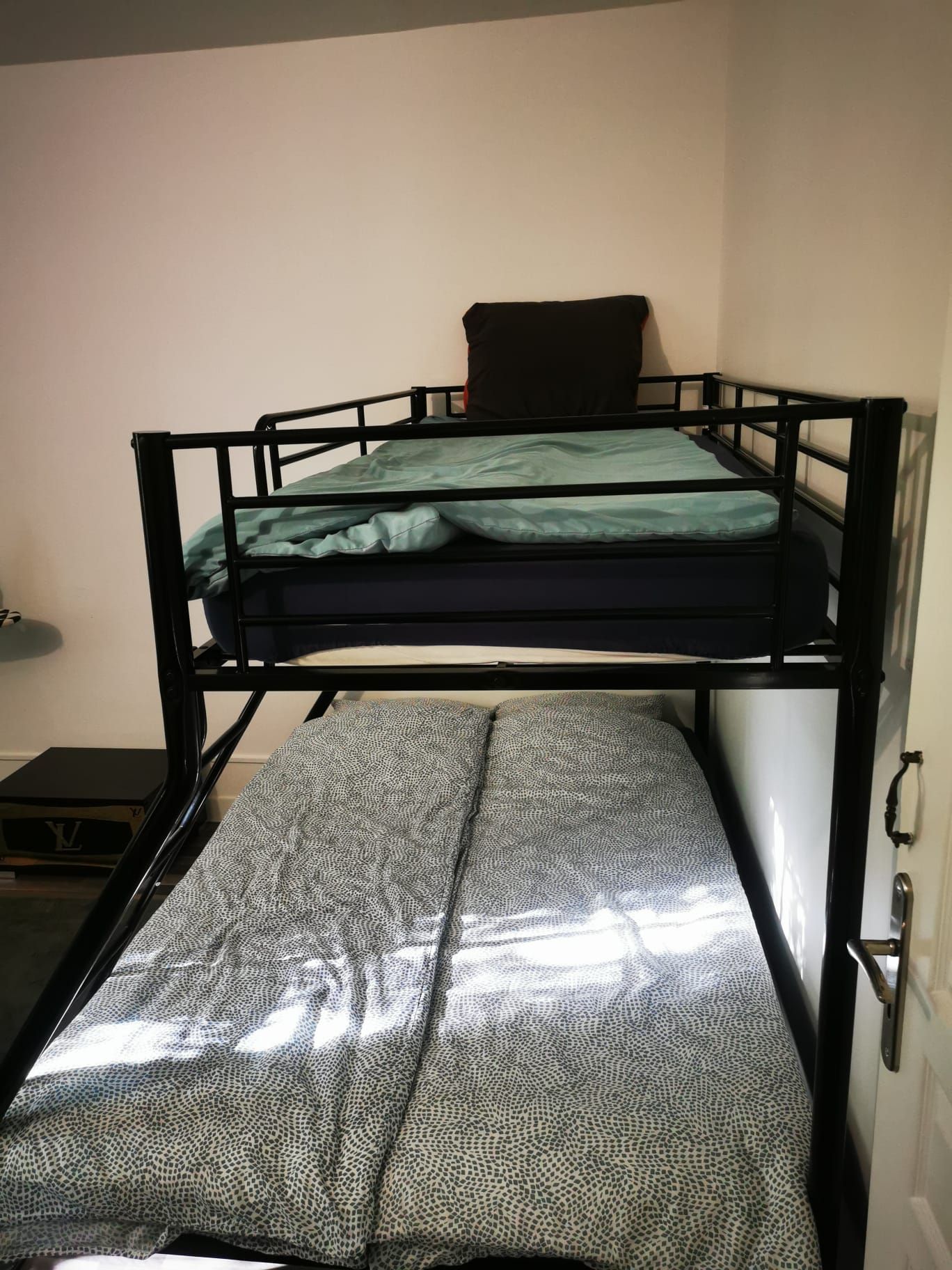 A bunk bed with a lower bunk and a mattress on the floor.