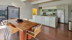 Een moderne keuken met witte kasten, een roestvrijstalen koelkast en een inbouwoven.
