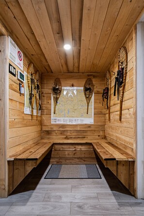 A sauna room with wooden walls, benches, and a map on the wall. - Le Coyote 5 acre private forest (Chertsey)