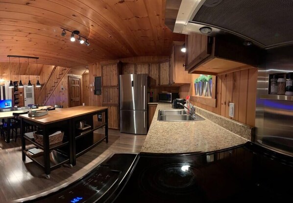 Una cocina moderna con armarios de madera, electrodomésticos de acero inoxidable y encimera de granito.
