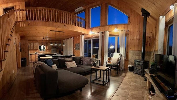 Un interior de madera con un sofá, una mesa y una chimenea.