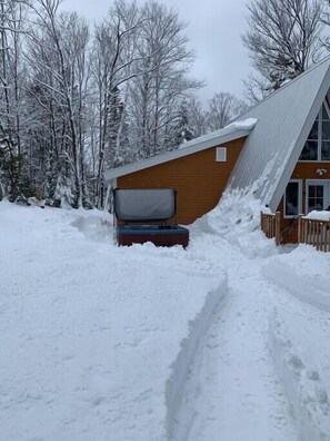 A snow-covered path leading to a cabin with a wooden exterior and a sloped roof. - Le Petit Lièvre CITQ 298679 (Chertsey)