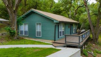 Situated in a secluded wooded area, this cabin features a front porch and a natural setting.