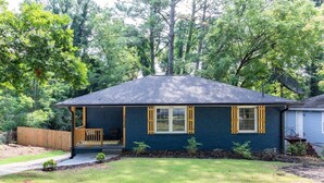 A single-story house with a dark blue exterior and yellow shutters, a front porch, and a small front yard. - 🔥 Spacious 3BR Basement APT near ATL Airport/ 10 Mins Downtown! Sleeps 8🔥 (East Point)