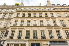 A historic building with multiple stories, featuring classic architectural details such as ornate balconies and decorative moldings. - Merveil - Family Suite - Opera - Castellane (Paris)