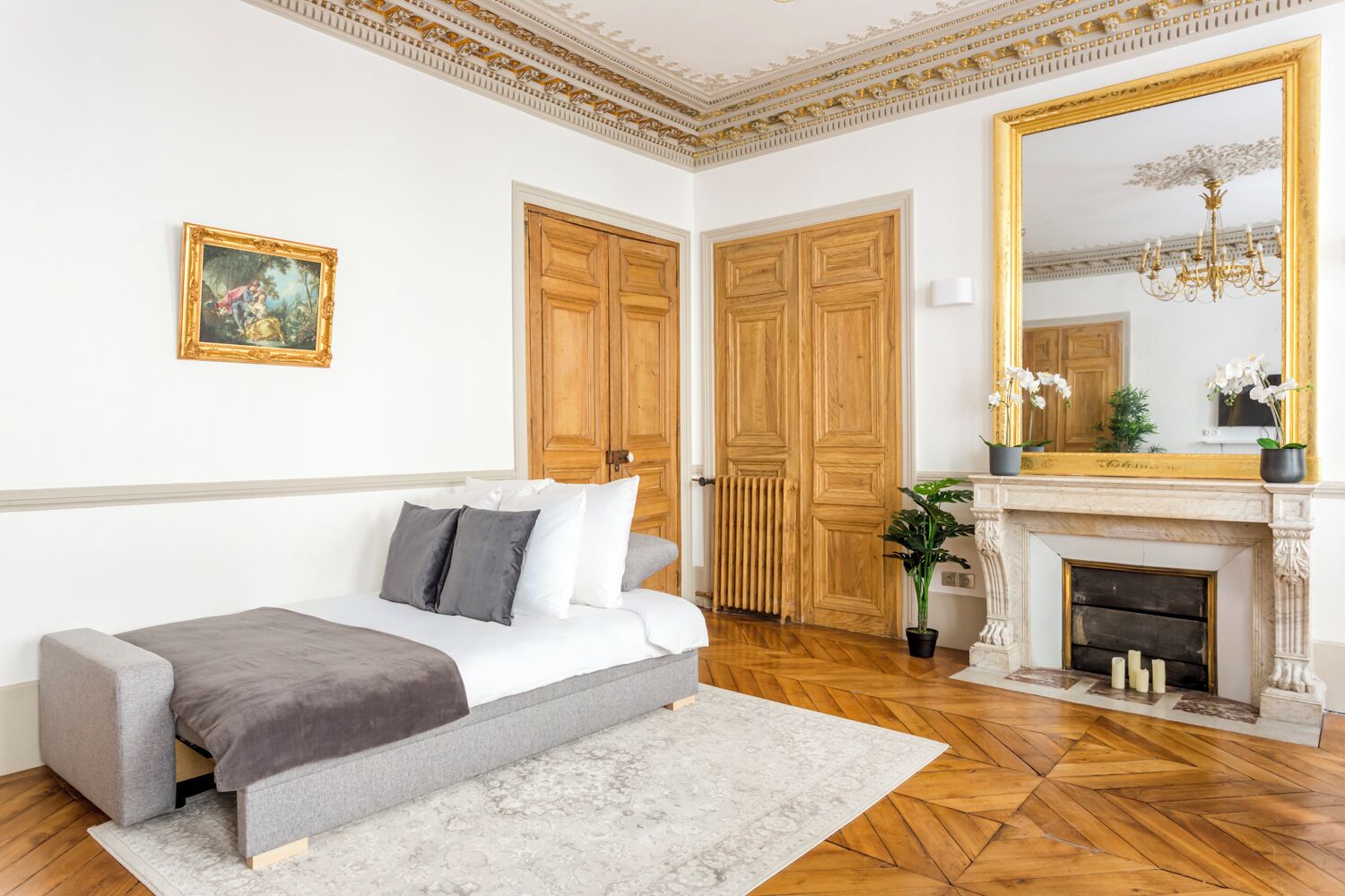 Una camera da letto con un letto, un camino e un grande specchio.