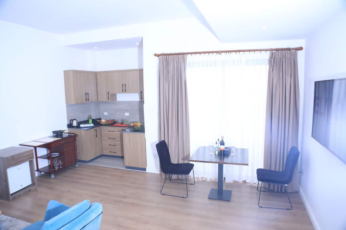 A modern kitchen with wooden cabinets and a dining area with a table and chairs.