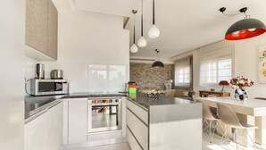A modern kitchen with a central island, stainless steel appliances, and pendant lighting. - Wonderfull duplex 3BR Hakovshim SAFE ROOM ({{addressCityy}})