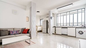 Un appartement moderne comprenant un espace de vie, une cuisine et un coin buanderie.