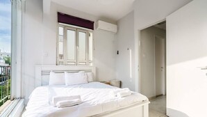 Une chambre moderne avec un grand lit, une fenêtre donnant sur un beau paysage et un appareil de climatisation.