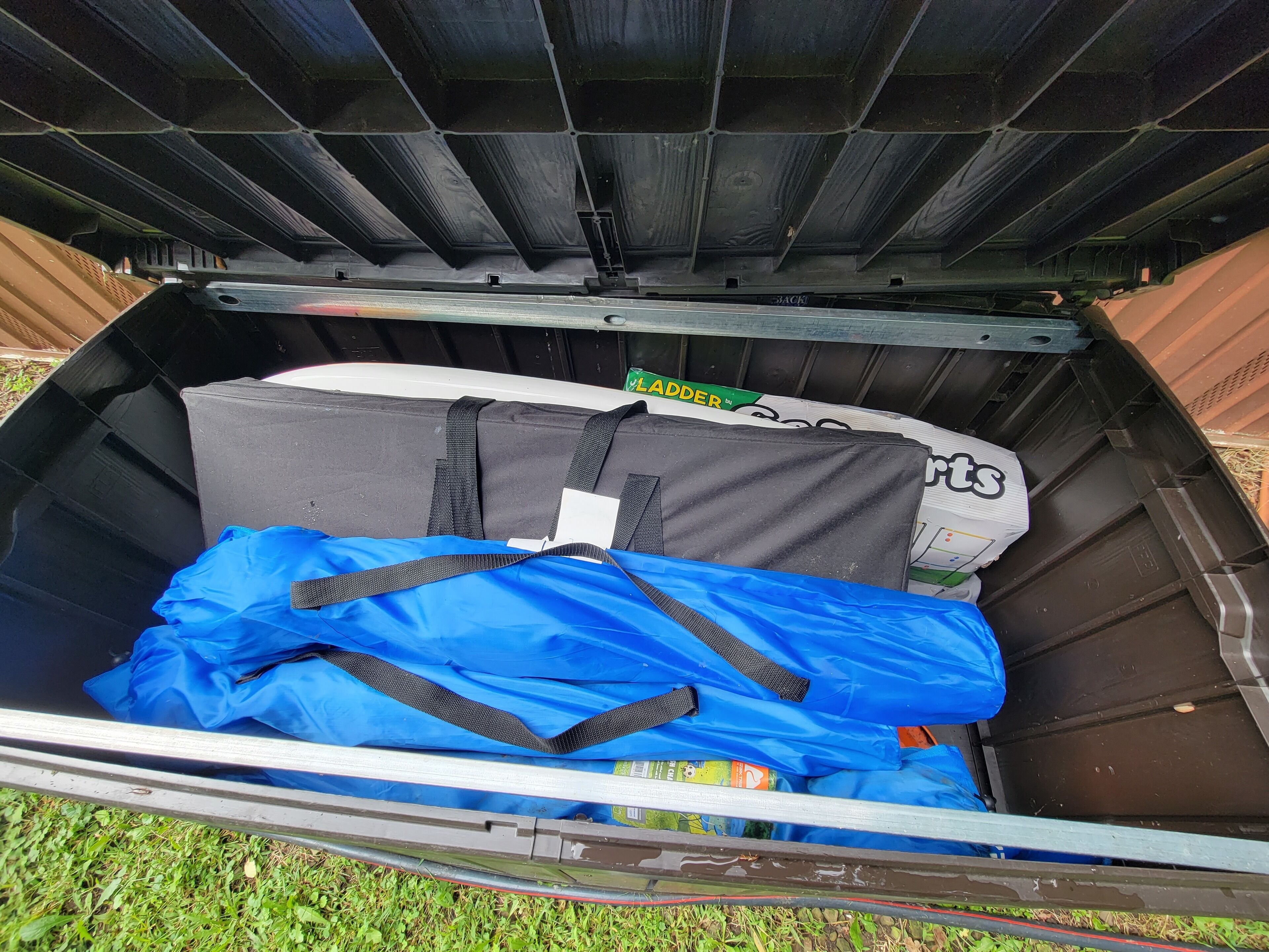 A large black container with a blue bag and a white box inside.