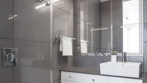 Une salle de bain moderne avec des toilettes, un lavabo et un miroir.