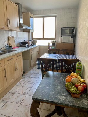 Een microgolfoven, een oven, een vaatwasser, een eettafel