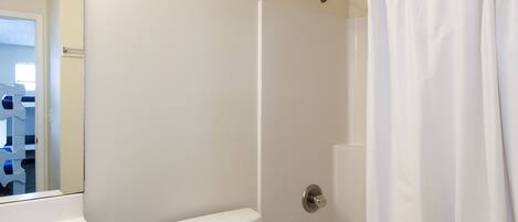 Un baño con inodoro, bañera y cortina de ducha.