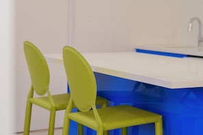 A kitchen area with a white countertop and blue cabinets.