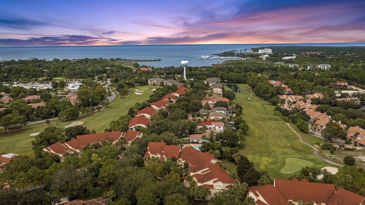 An aerial view of a residential area with houses, a golf course, and a water tower.