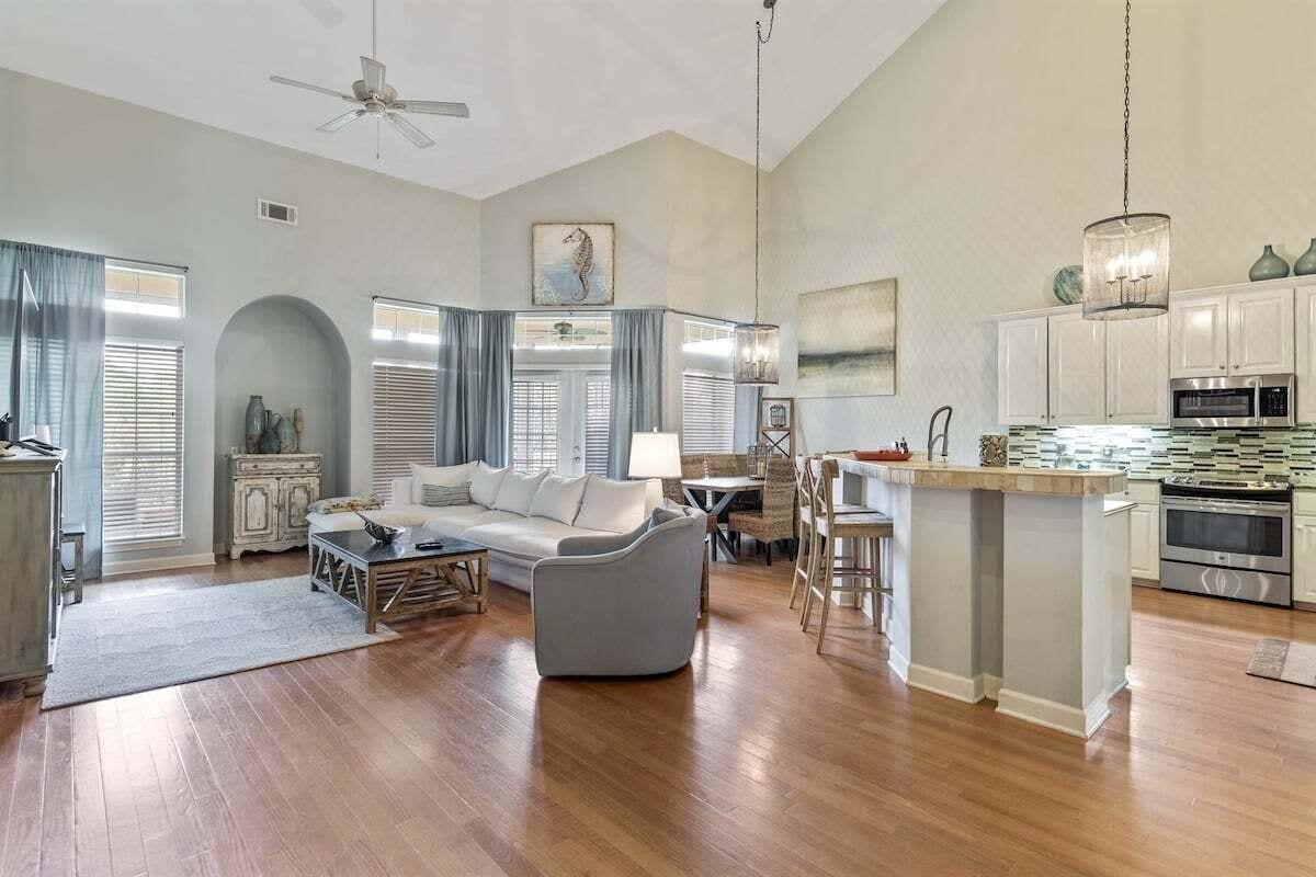 A spacious living room with a sofa, dining area, and kitchen with modern appliances.