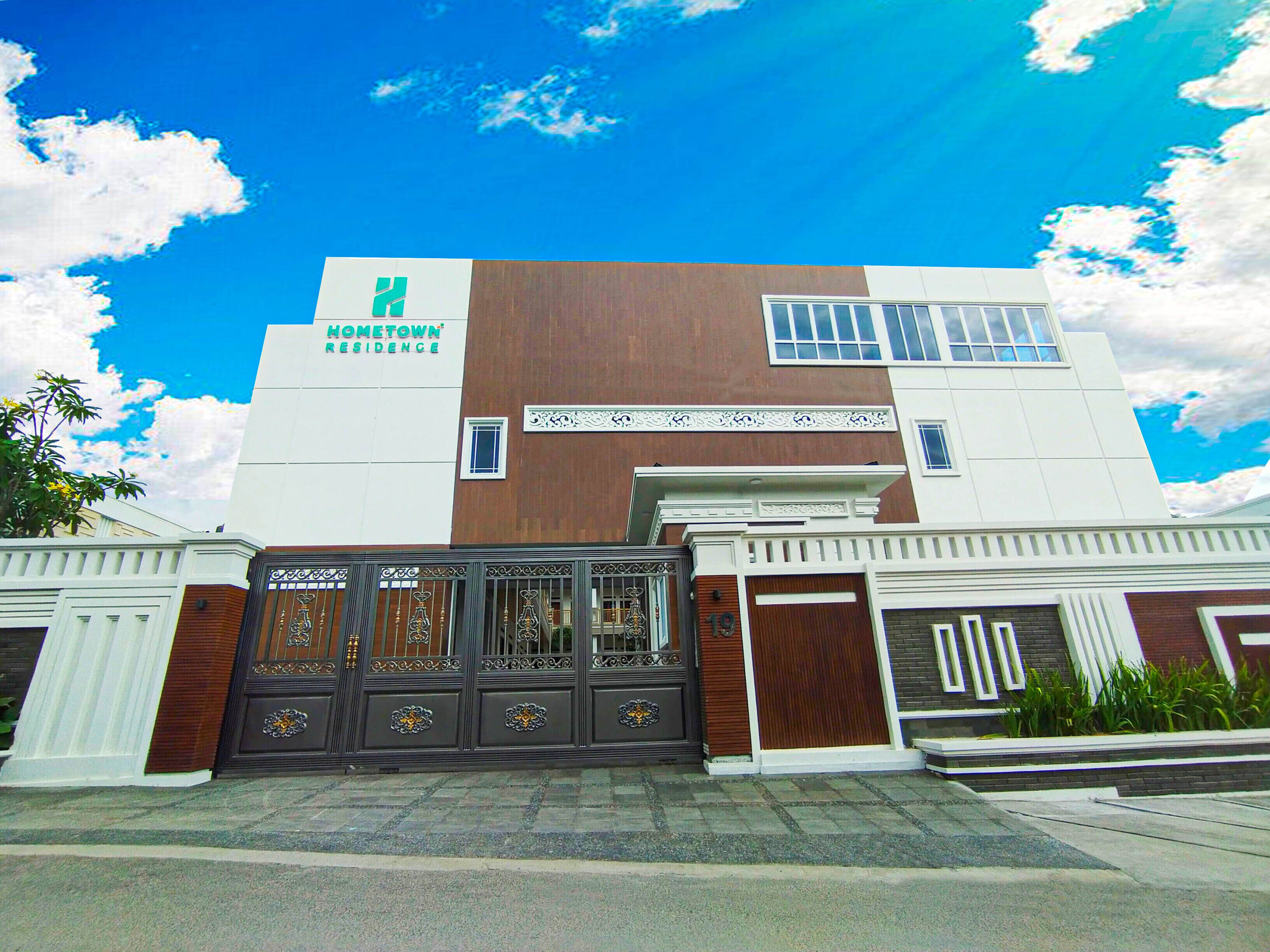 A two-story building with a sign reading "HOMETOWN RESIDENCE".