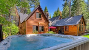 A wooden cabin with a hot tub in front. - Finch Haven in Homewood (Homewood)