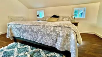 A bedroom with a bed, bedside tables, a window, and a patterned rug.