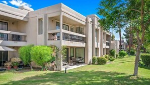 A modern multi-story hotel with a flat roof, balconies, and a well-maintained lawn. - Canyon Shores Desert Escape! (Cathedral City)