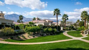 A residential area with houses, palm trees, and a mountain in the background. - Affordable Desert Getaway w/ Private Pool + Hot Tub! (La Quinta)