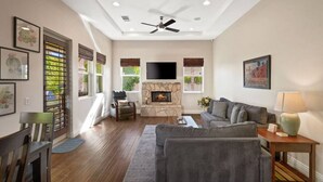 A spacious living room with a fireplace, comfortable seating, and a flat-screen TV. - Affordable Desert Getaway w/ Private Pool + Hot Tub! (La Quinta)