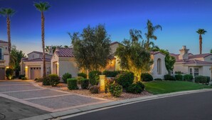 A residential area with houses featuring red-tiled roofs and stucco walls, surrounded by well-maintained landscaping and palm trees. - Affordable Desert Getaway w/ Private Pool + Hot Tub! (La Quinta)
