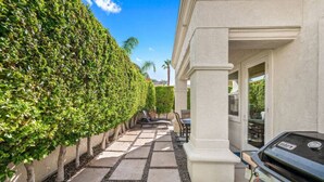 A paved pathway leading to a patio area with a grill and outdoor seating. - Affordable Desert Getaway w/ Private Pool + Hot Tub! (La Quinta)