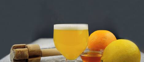 Ein Glas Bier, eine Orange und eine Zitrone auf einer Steinoberfläche.