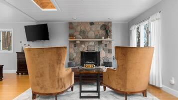 TV connectée, cheminée, livres, chaîne hi-fi