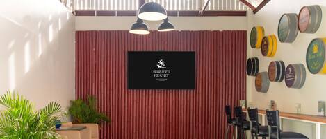 Un espace bar avec un décor de bambou rouge, une enseigne noire indiquant « SLUMBER RESORT », et un mur composé de barils de bière.