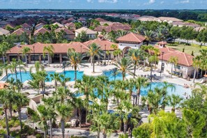 A resort with a large pool surrounded by palm trees and lounge chairs. - 5-bedroom pool home with spa and Mario game room at Solterra Resort, near Disney (Davenport)